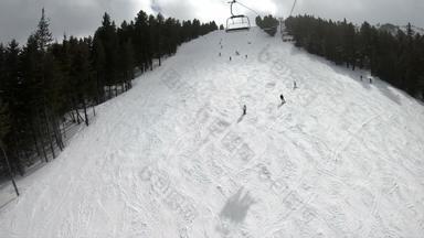 滑雪者单板滑雪下坡山坡滑雪度假胜地雪森林滑雪电梯山背景清晰的天空观点慢运动
